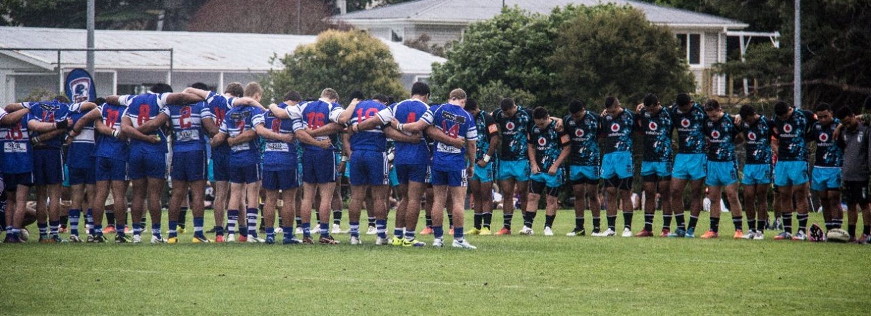 Players from the Vodafone Warriors Academy and Glenora teams observe a moment's silence before their game at the Luke Tipene Celebration Day. Image | www.warriors.kiwi