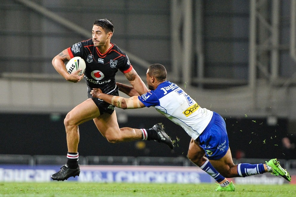 Shaun Johnson of The Warriors fends off Moses Mbye of the Bulldogs during the NRL Rugby League match